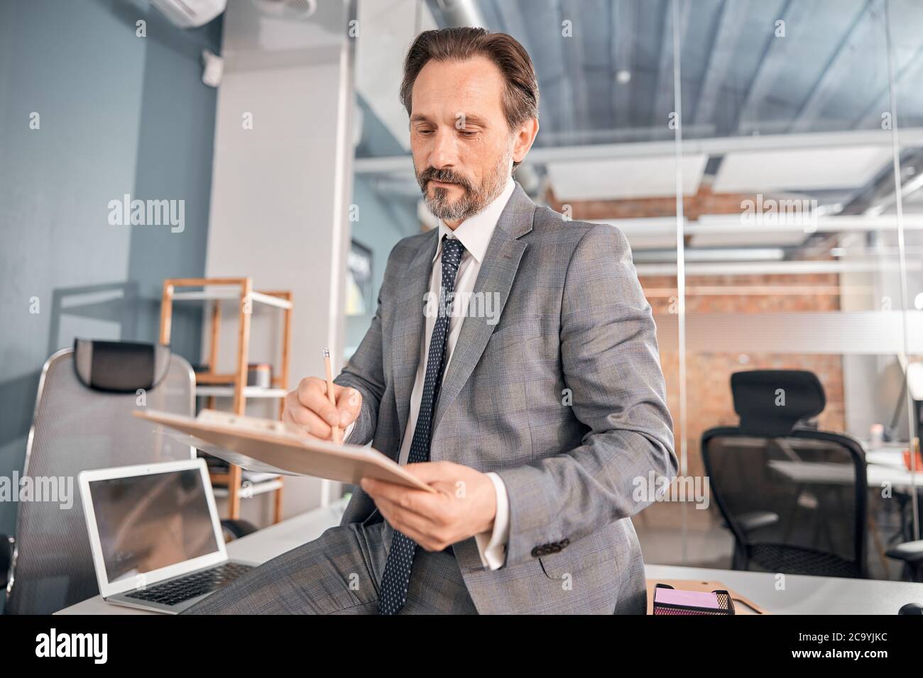 Handsome male worker studying documents in office Stock Photo