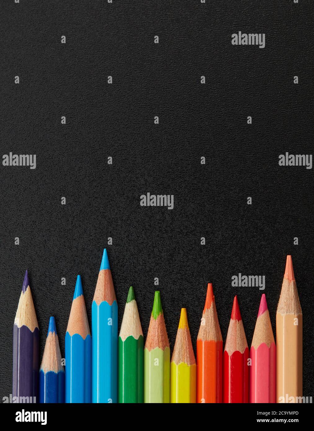 Multi-colored pencils on blackboard Stock Photo