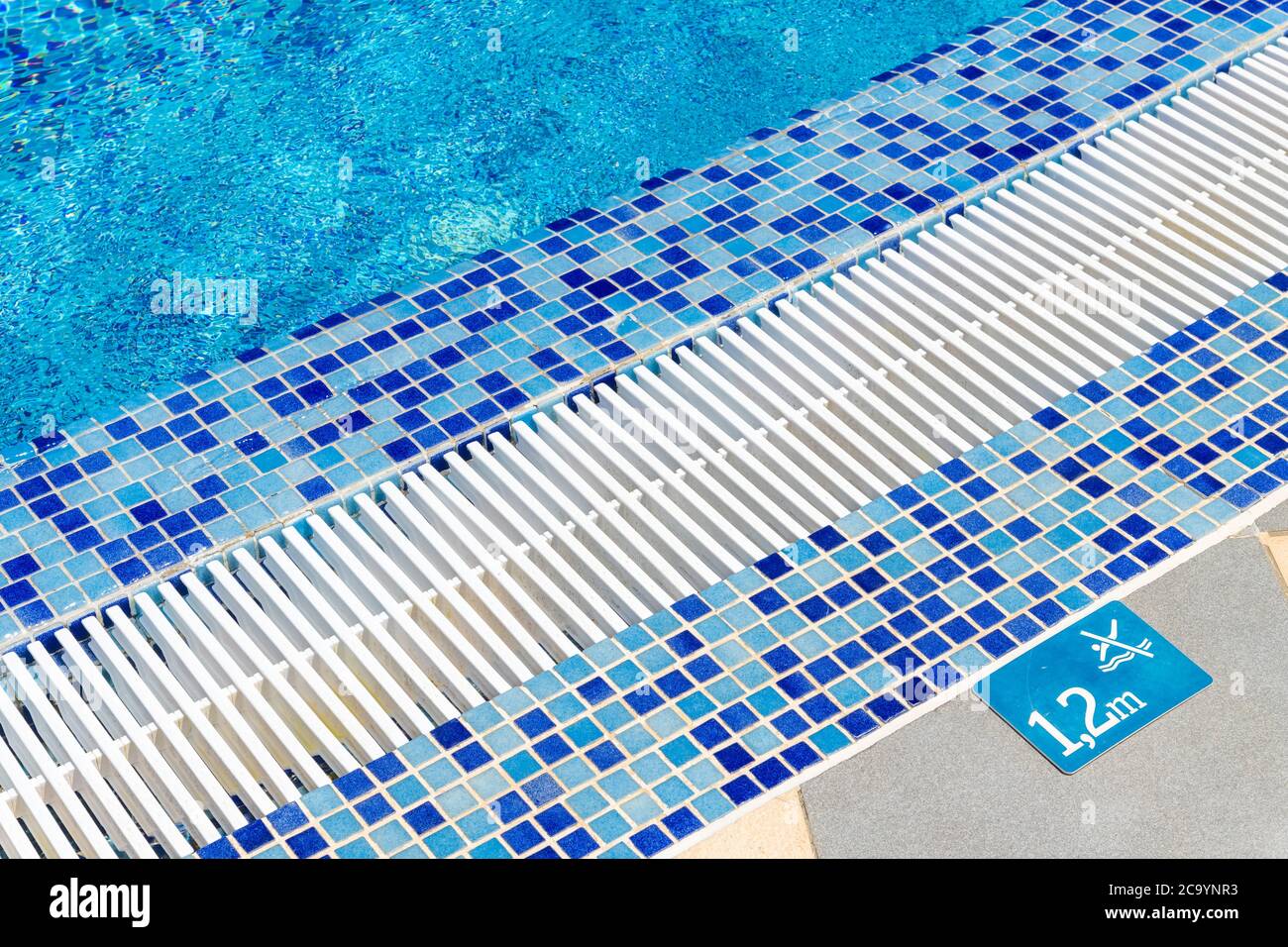 Edge of pool with indication of depth of 1.2 meters and sign that prohibits jumping Stock Photo