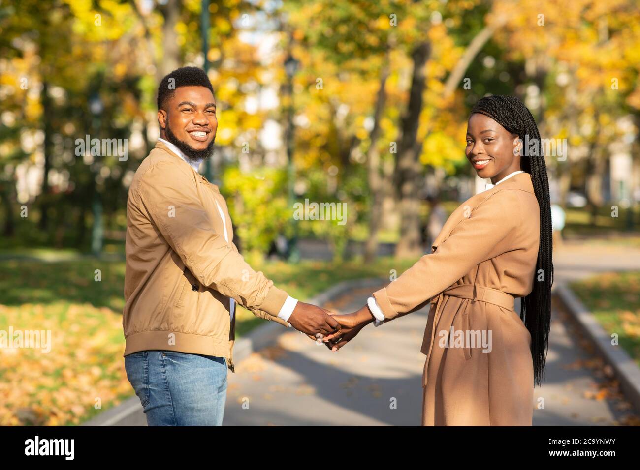 Portrait of happy afro couple holding hands on date outdoors Stock ...