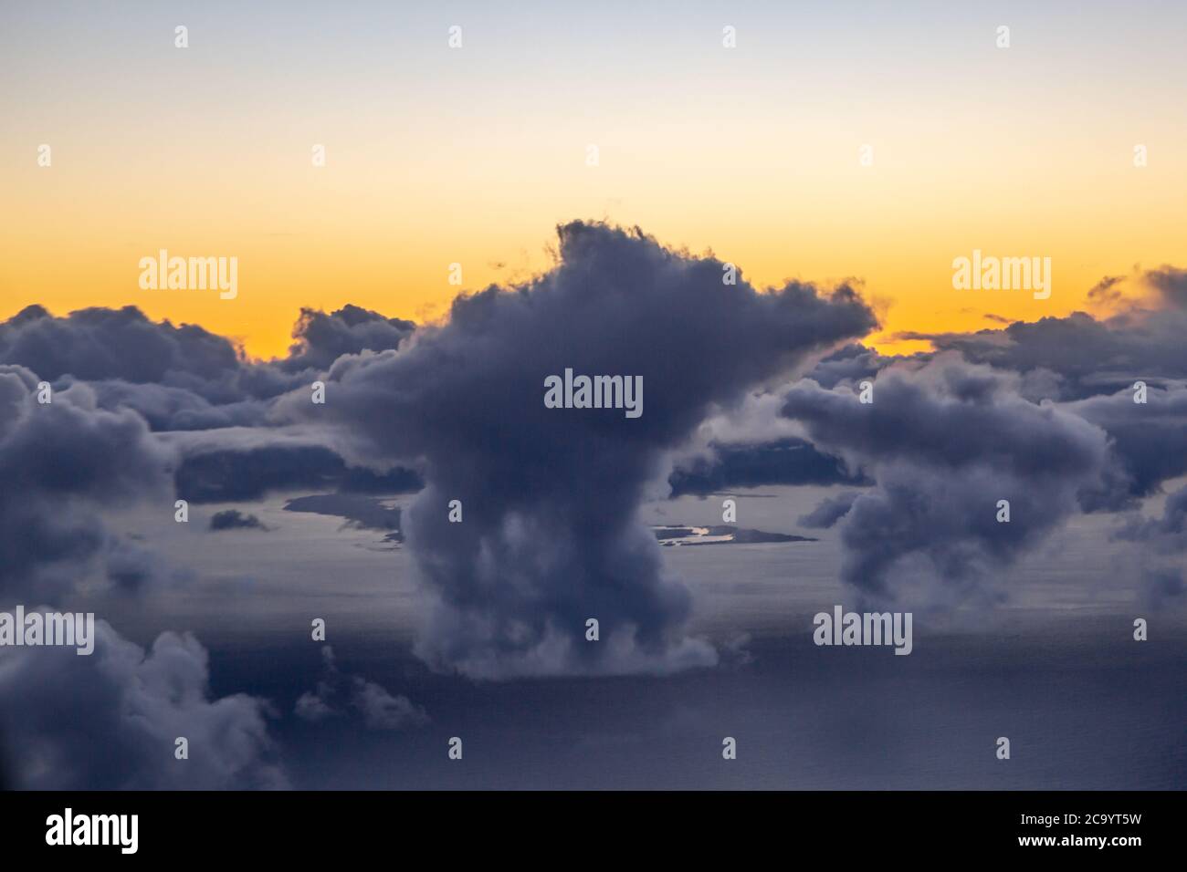 Dramatic clouds over the ocean at sunset, viewed from an airplane Stock Photo