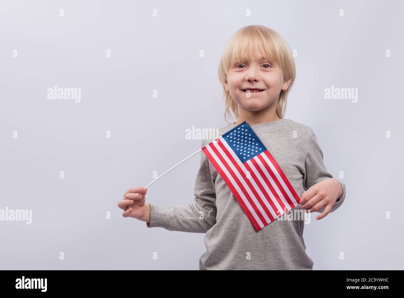 Young boy holding an American flag on white background. Study of ...