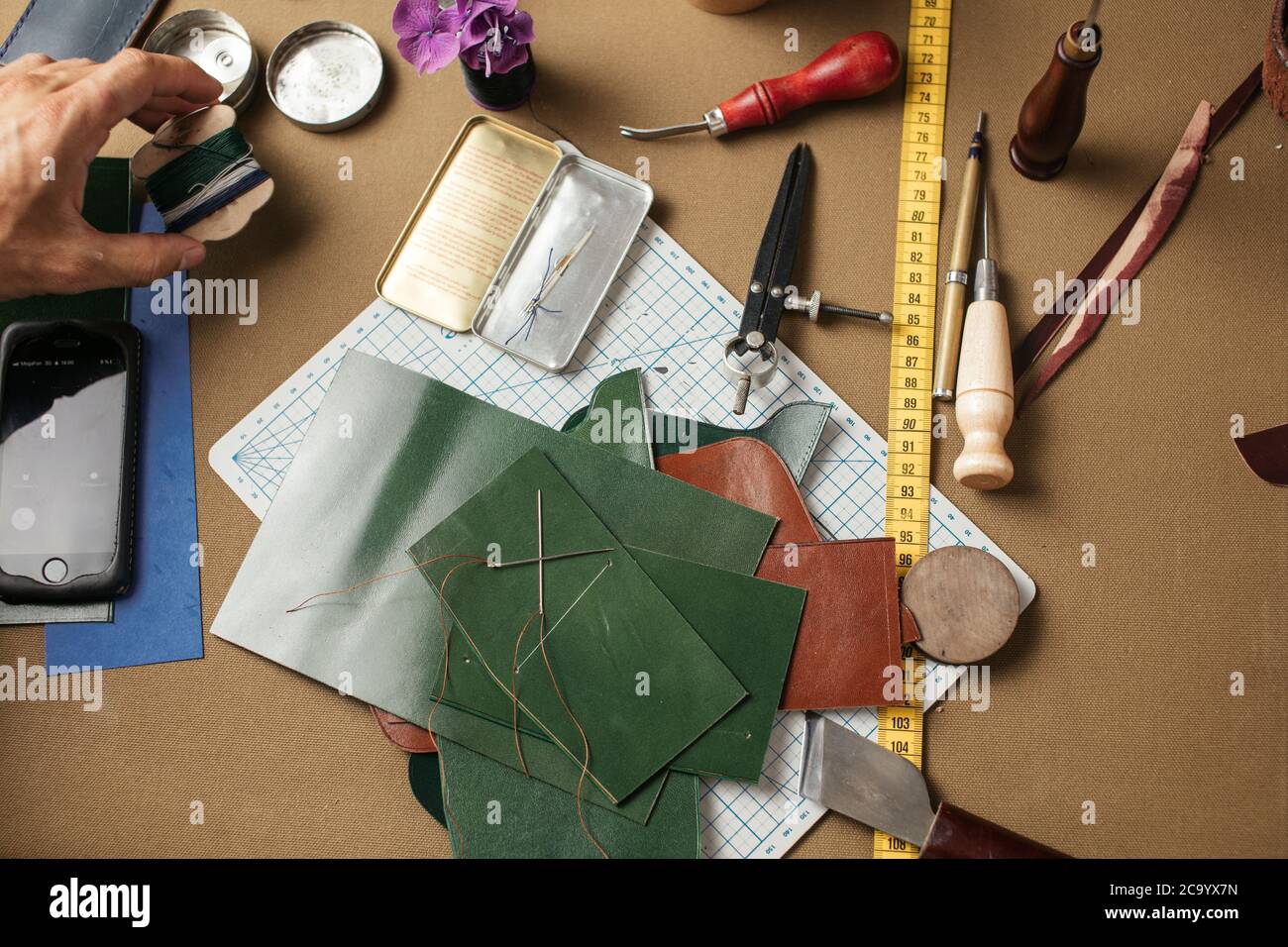 Leathersmith's work desk . Pieces of hide and leather working tools on a  work table. Stock Photo by ©Volurol 109514284