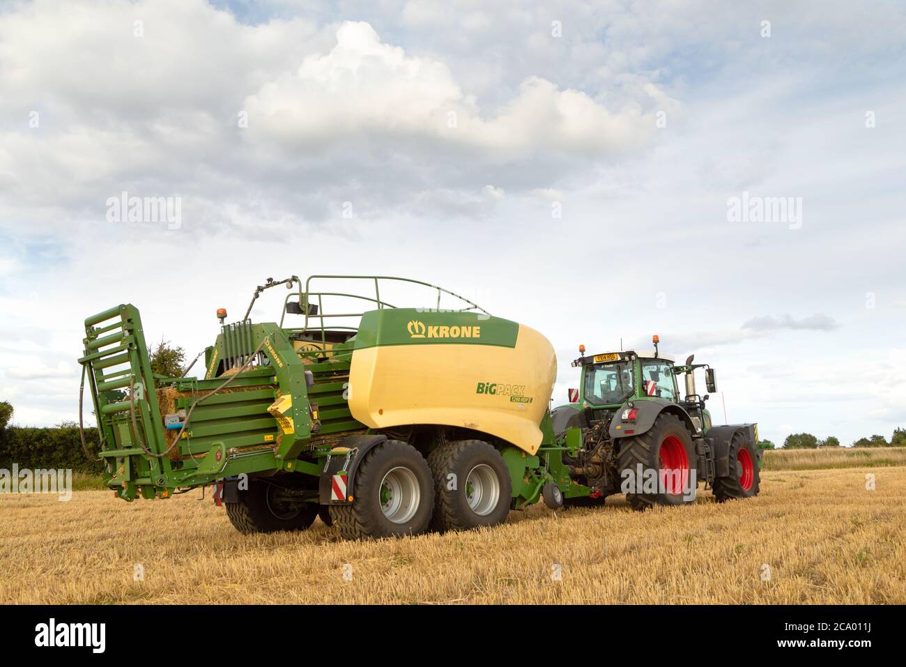 Rear view of a tractor using a hay baler in a field. Much Hadham, Hertfordshire. UK. Stock Photo