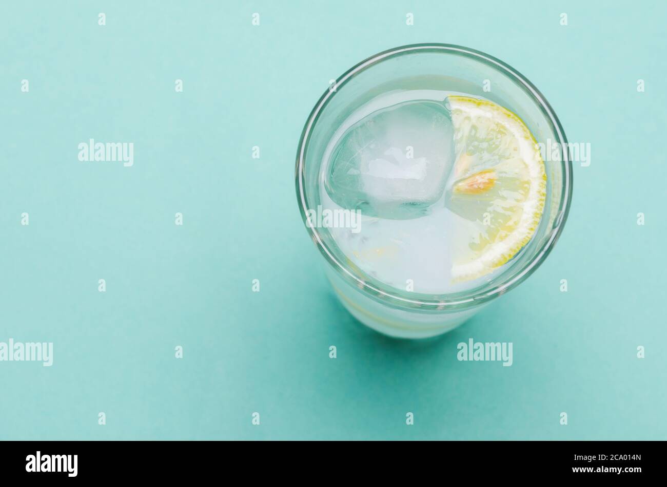 Cocktail with ice and lemon slice on bright blue background Stock Photo ...