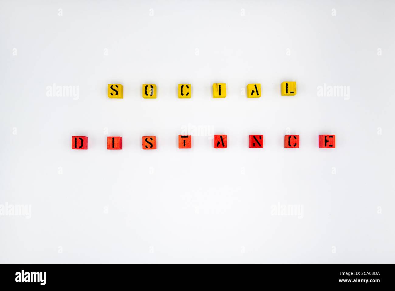 Yellow and red wooden cubes with message Social Distancing isolated on white background Stock Photo
