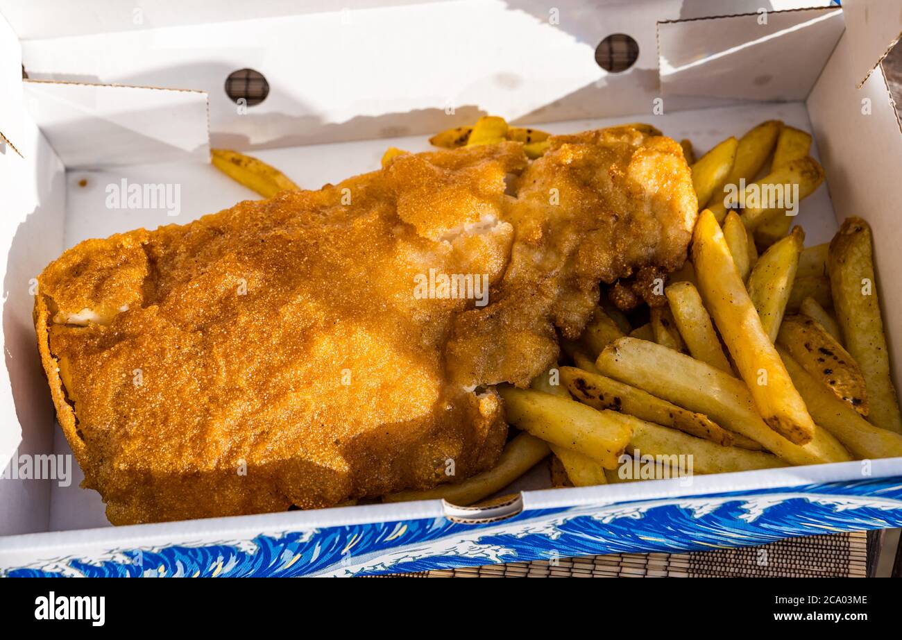 Haddock fish and chips or fish supper in takeaway box in Summer sunshine, Scotland, UK Stock Photo