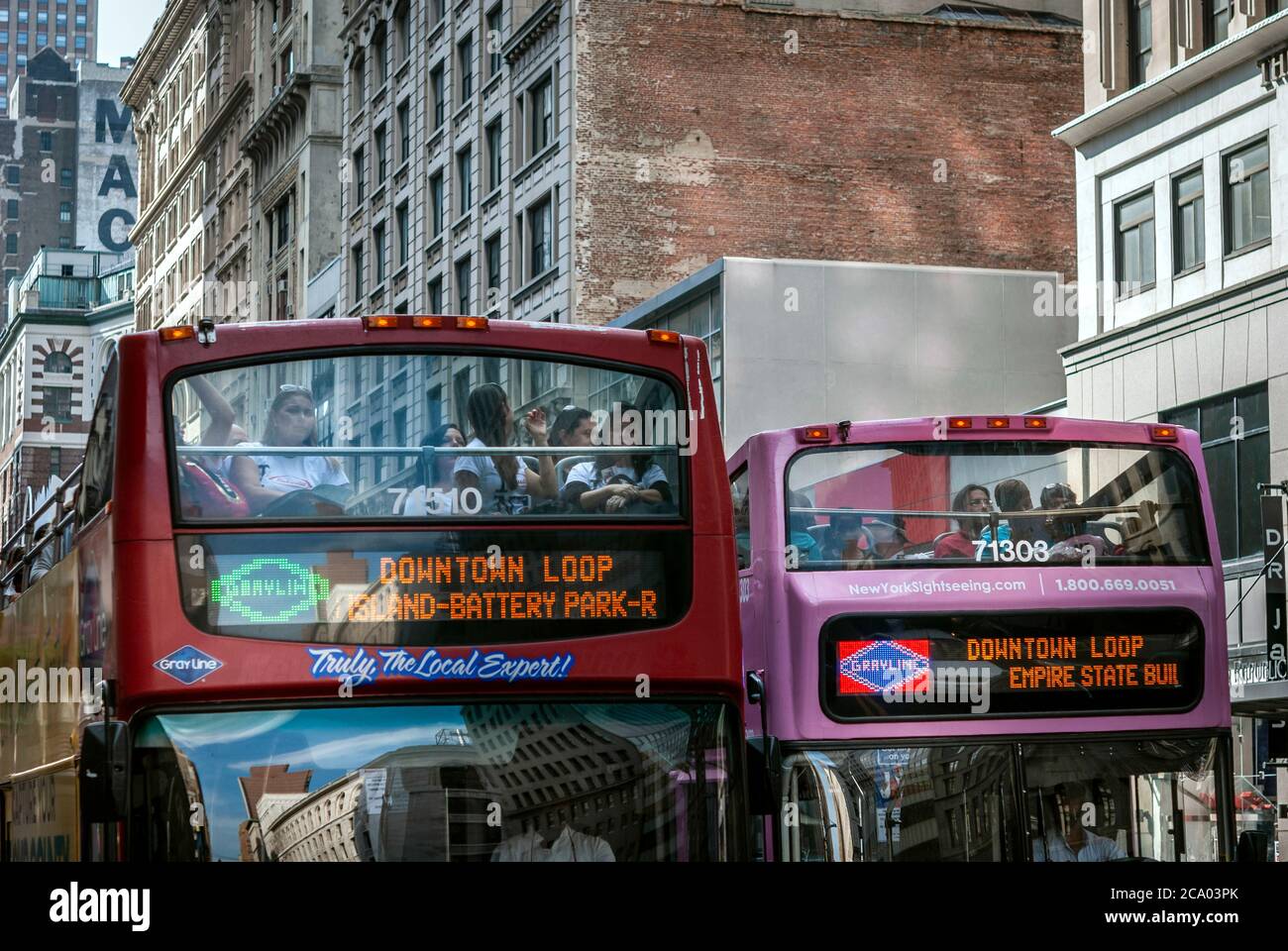 Hop On Hop Off sightseeing buses carrying tourists in Soho area in New York Stock Photo