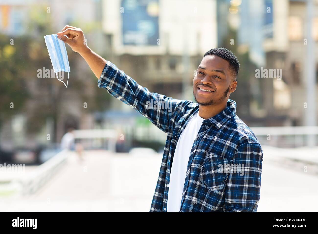 Portrait of afro man taking off mask in the downtown Stock Photo