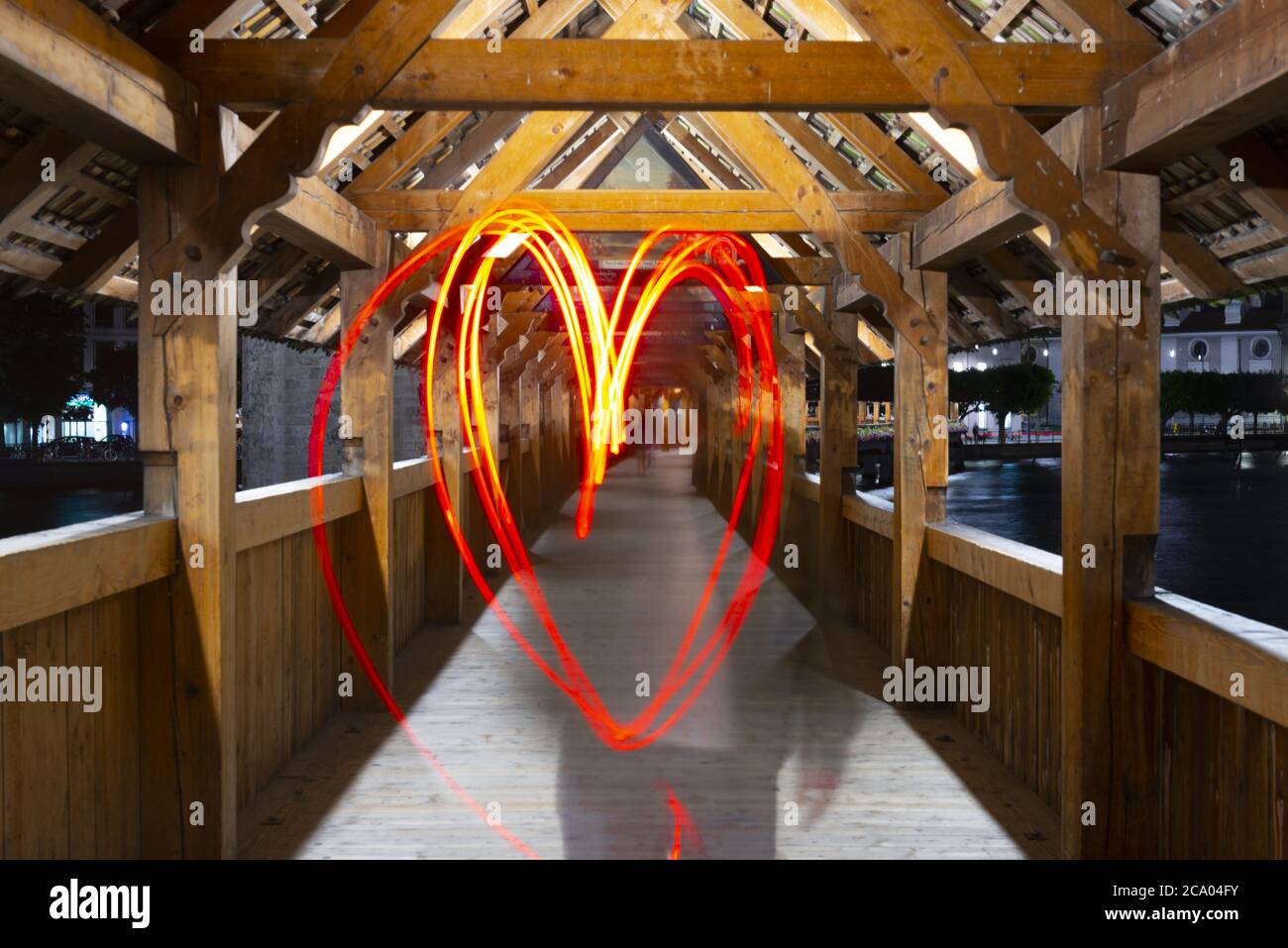 One Person Making a Heartshape with Light Painting on Chapel Bridge (Kapellbrucke) in Lucerne, Switzerland. Stock Photo