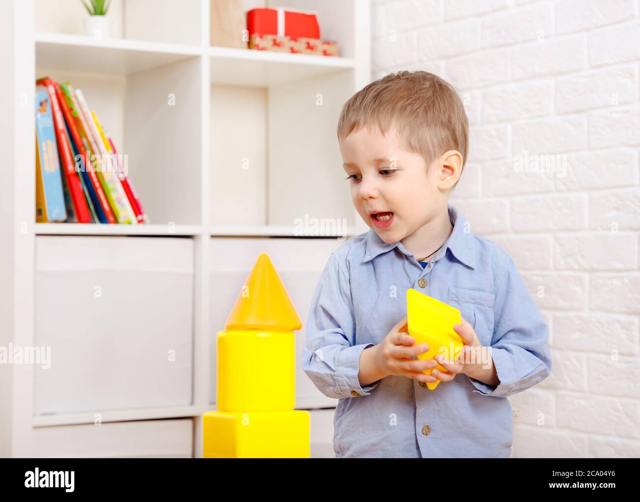 Nice child playing with constructor on floor at home Stock Photo
