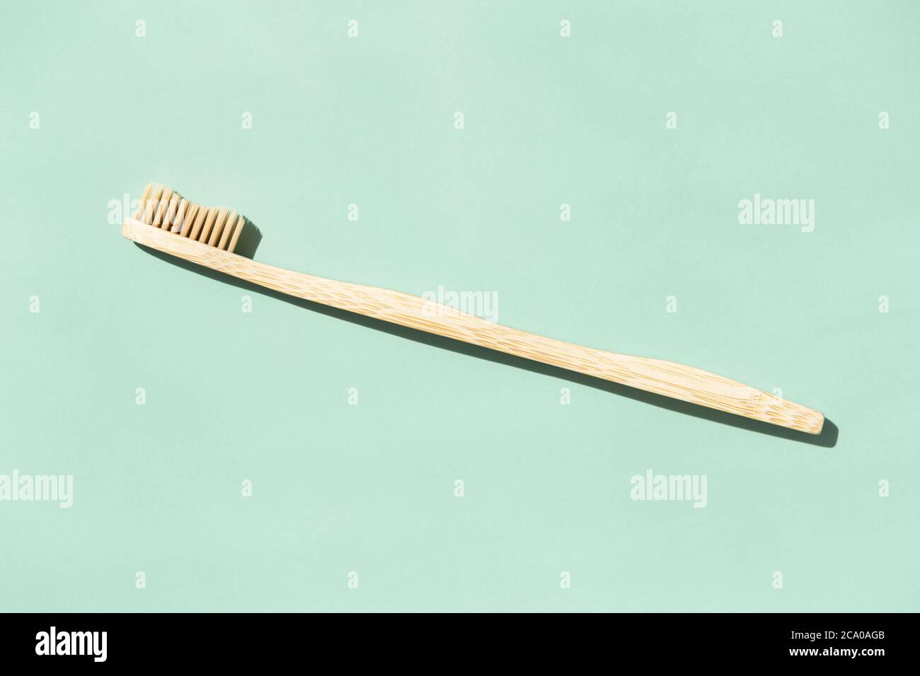 Bamboo toothbrush on mint background with copy space. Top view in ...