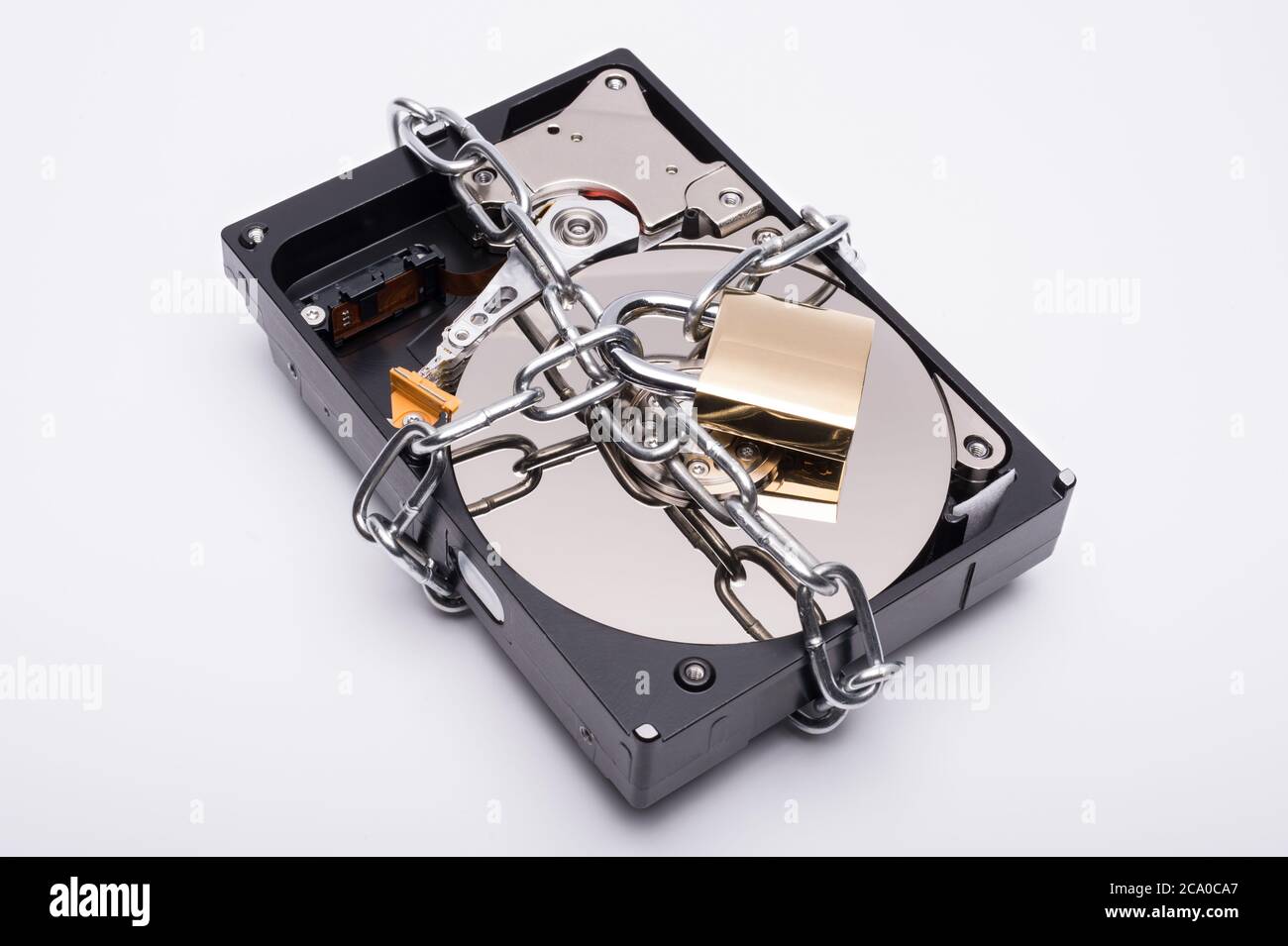 A 3.5' hard disk drive (HDD) secured by a chain and padlock. Stock Photo