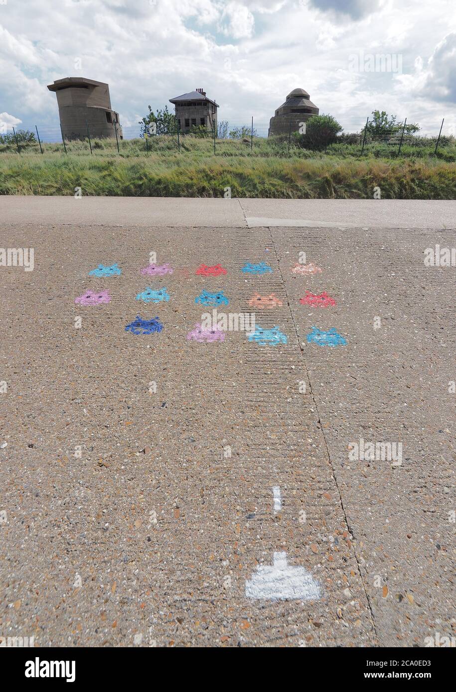 Sheerness, Kent, UK. 3rd August, 2020. A depiction of classic late '70's / 1980s computer game 'Space Invaders' has appeared on the sea wall at Sheerness, Kent in front of three old defensive gun towers. Credit: James Bell/Alamy Live News Stock Photo