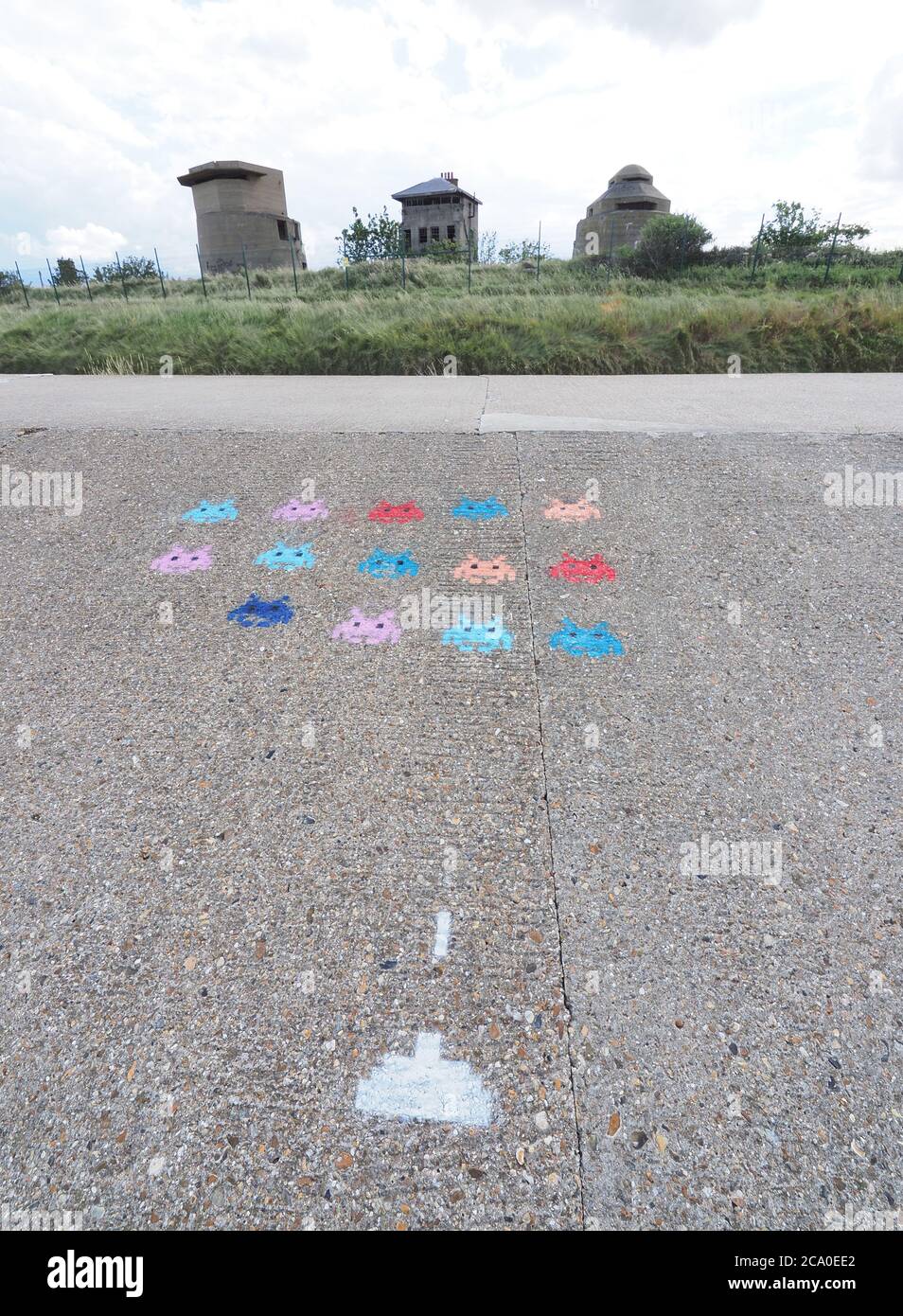 Sheerness, Kent, UK. 3rd August, 2020. A depiction of classic late '70's / 1980s computer game 'Space Invaders' has appeared on the sea wall at Sheerness, Kent in front of three old defensive gun towers. Credit: James Bell/Alamy Live News Stock Photo