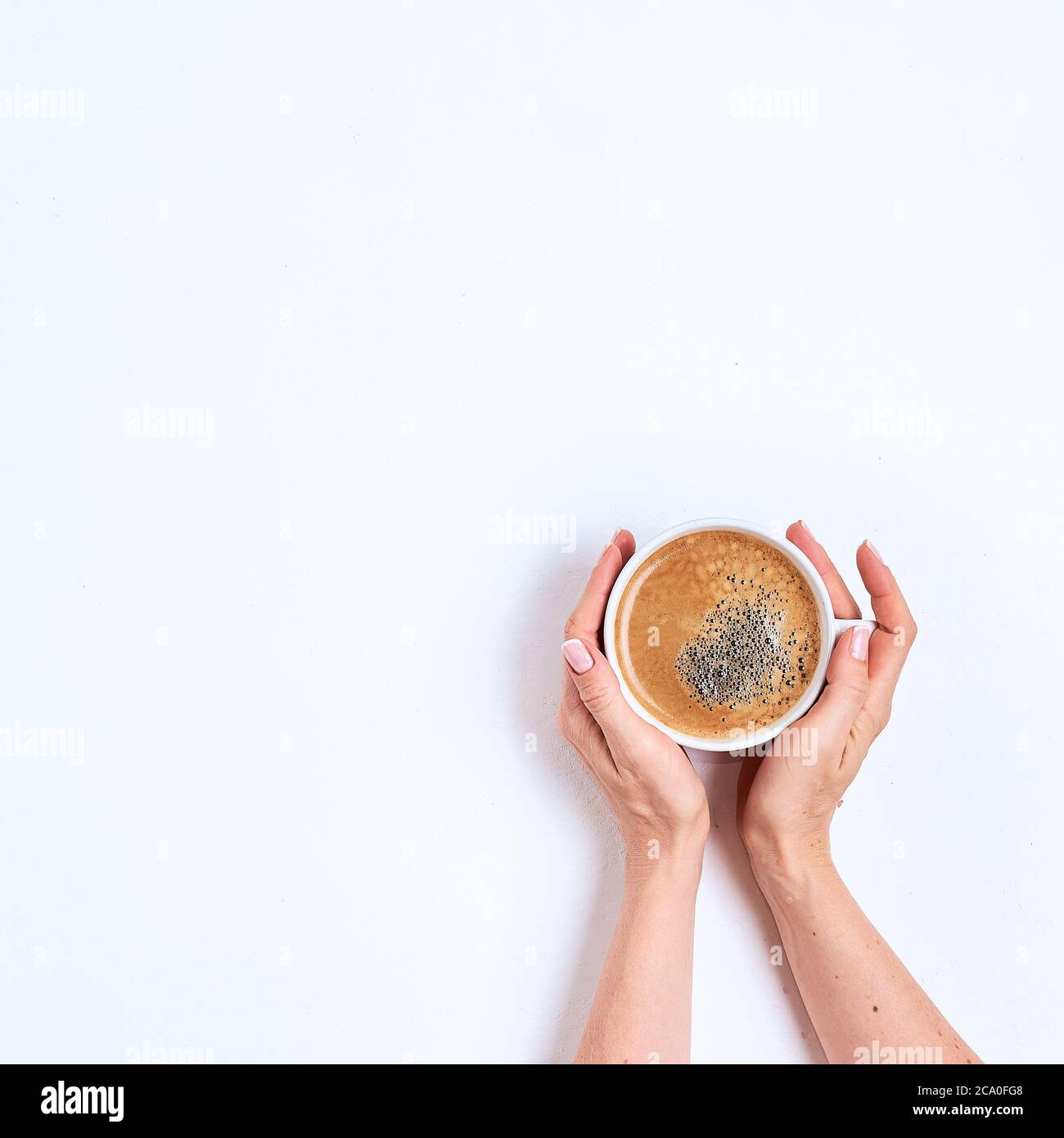 White coffee cup in female hands on a white background. Top view Stock  Photo - Alamy