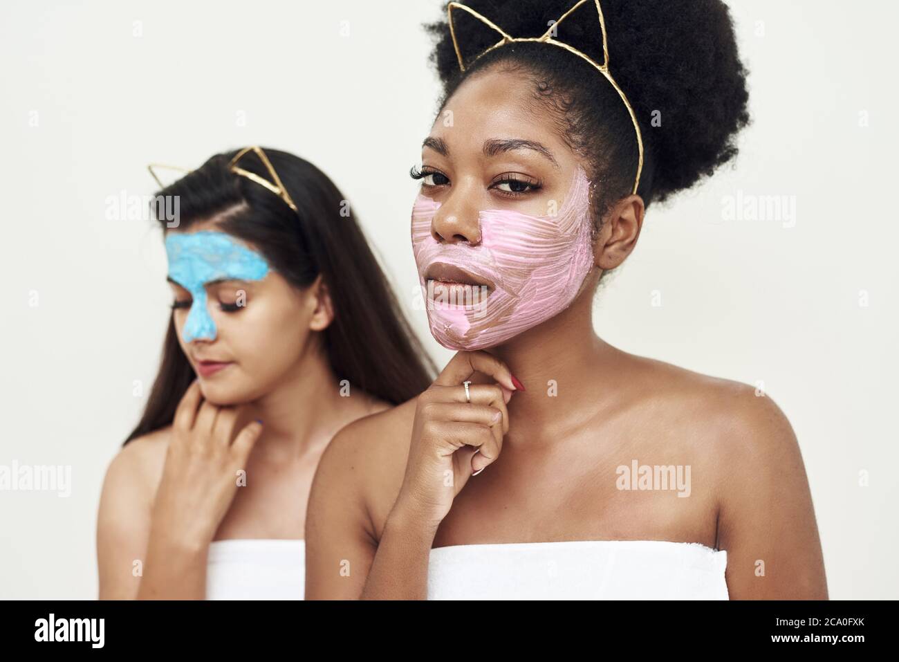 Multimasking. Two different ethnic girls are hugging. The girls' faces