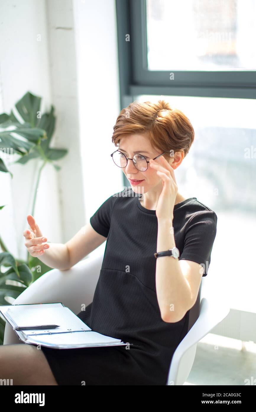 Smiling therapist taking notes and talking about something Stock Photo