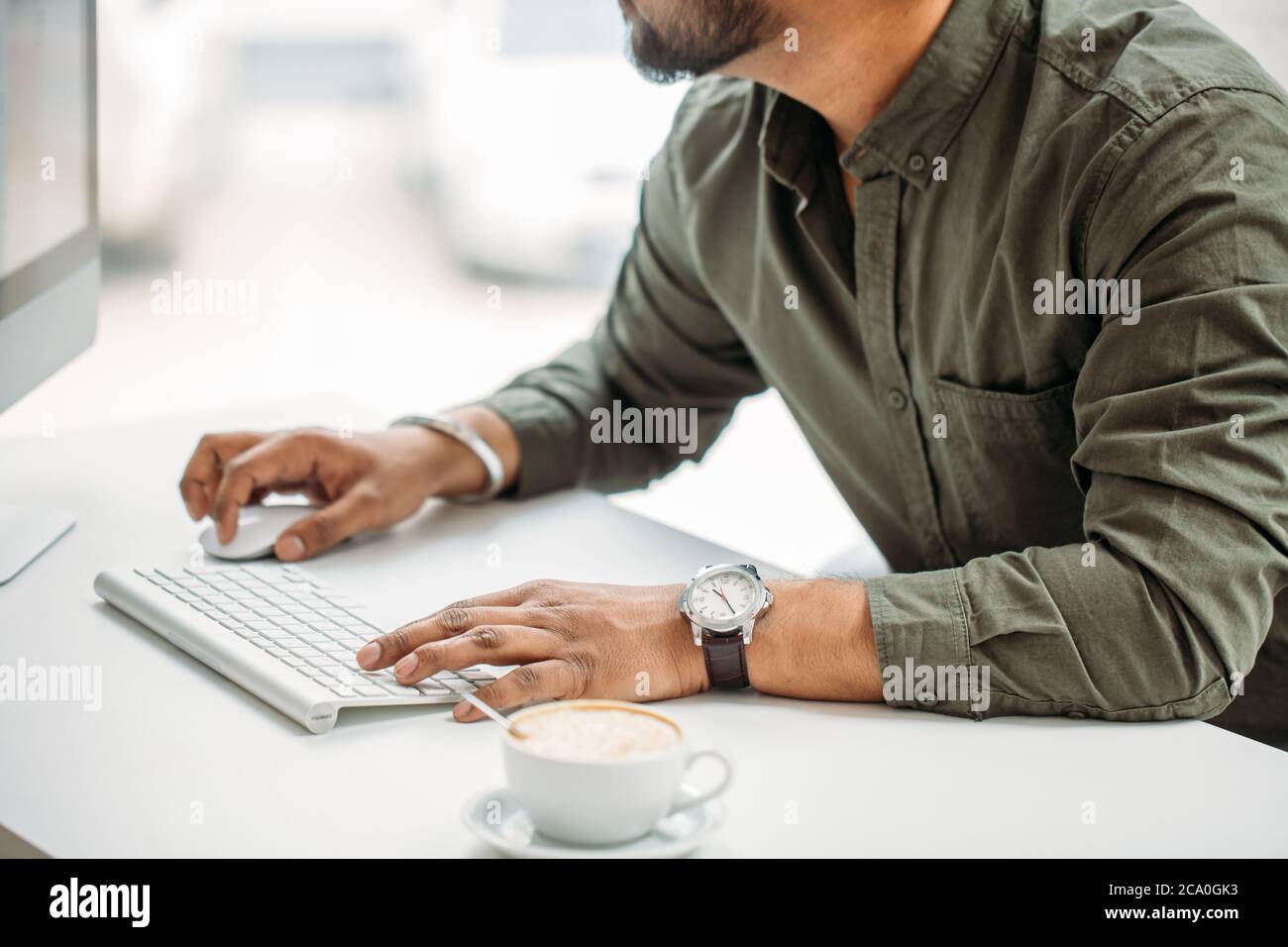 young indian man working at computer from modern bright office Stock Photo