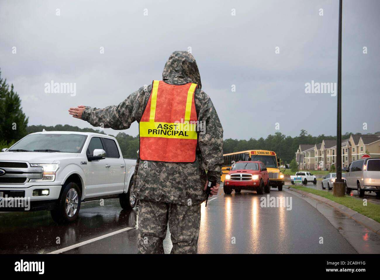 Canton, GA, USA. 3rd Aug, 2020. Assistant Principal John Carter directs traffic at Teasley Middle School on first day of classes for fall semester. Public schools in Cherokee County, GA, north of Atlanta reopened Monday in the midst of concern by a majority of teachers about adequate safety precautions against spreading Covid-19 infections. The county system is one of three in the Atlanta metro area with a large percentage of students opting for face-to-face classes. Most other counties chose to reopen with virtual learning. Credit: Robin Rayne/ZUMA Wire/Alamy Live News Stock Photo