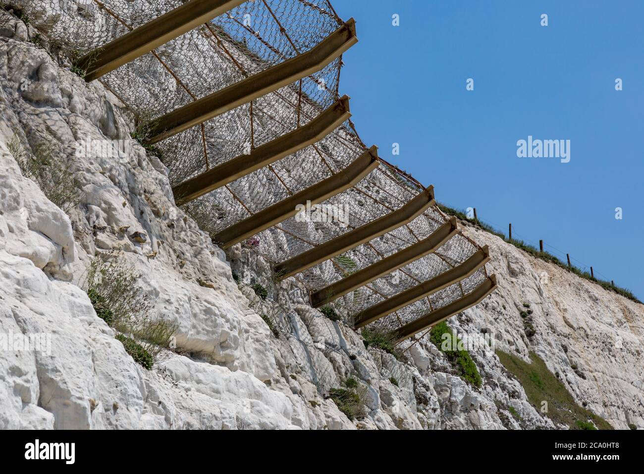 Protective netting on a chalk cliff to catch falling rocks Stock Photo ...