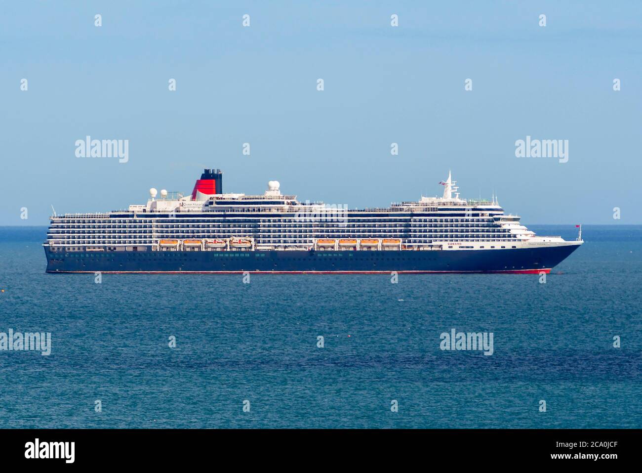 Weymouth, Dorset, UK.  3rd August 2020.  UK Weather.  Empty Cunard cruise ship Queen Victoria anchored in the bay at the seaside resort of Weymouth in Dorset on a day of hot sunny spells.  Picture Credit: Graham Hunt/Alamy Live News Stock Photo