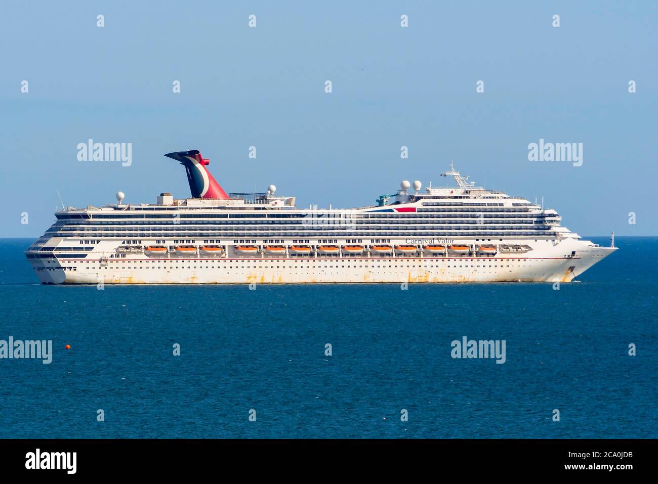 Weymouth, Dorset, UK.  3rd August 2020.  UK Weather.  Empty Carnival cruise ship Carnival Valor looking a bit rusty while it is anchored in the bay at the seaside resort of Weymouth in Dorset on a day of hot sunny spells.  Picture Credit: Graham Hunt/Alamy Live News Stock Photo