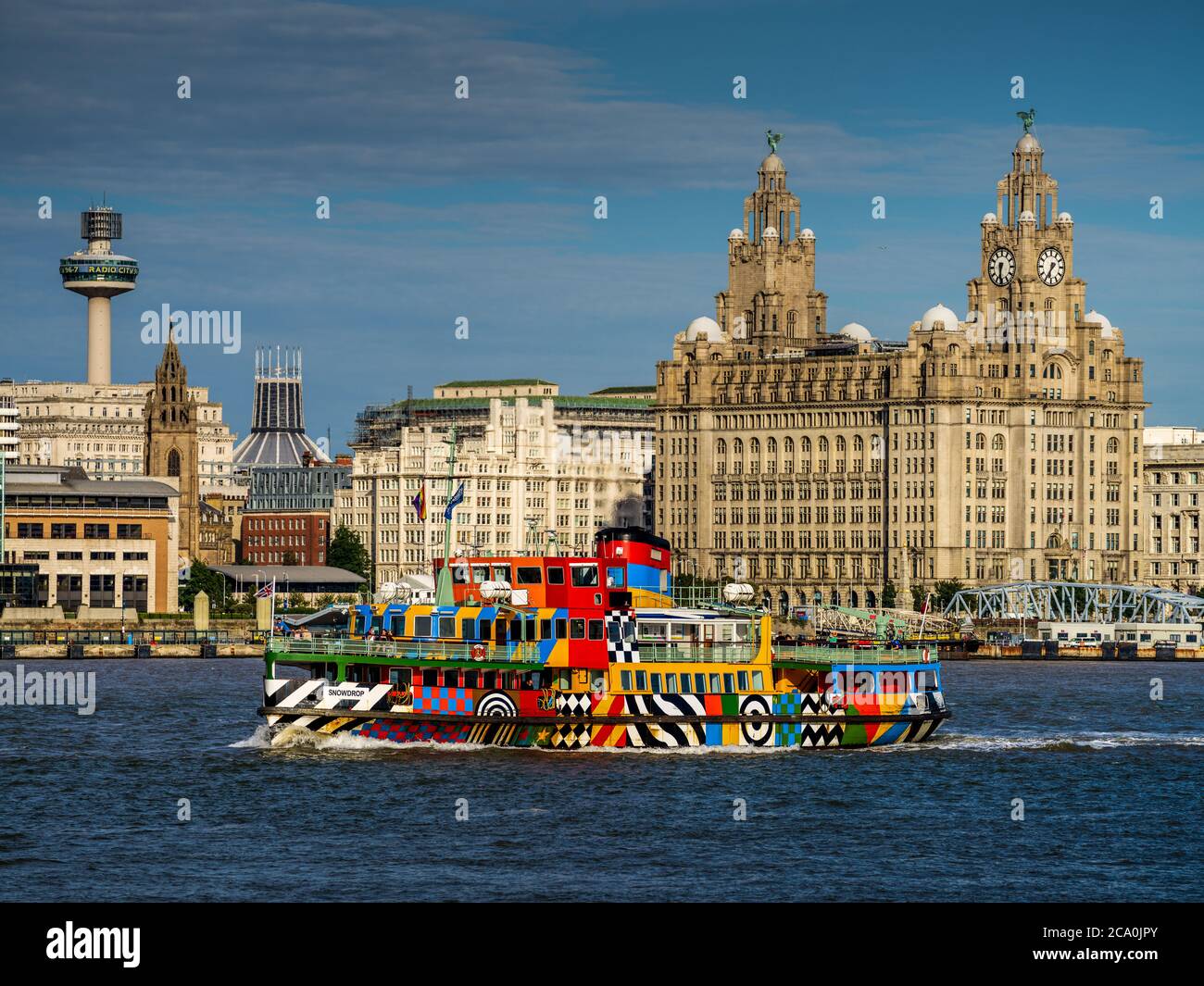 Mersey Ferry passes in front of the Royal Liver Building on the Liverpool waterfront. Built 1908-1911 it's one of the Liverpool Three Graces buildings. Stock Photo