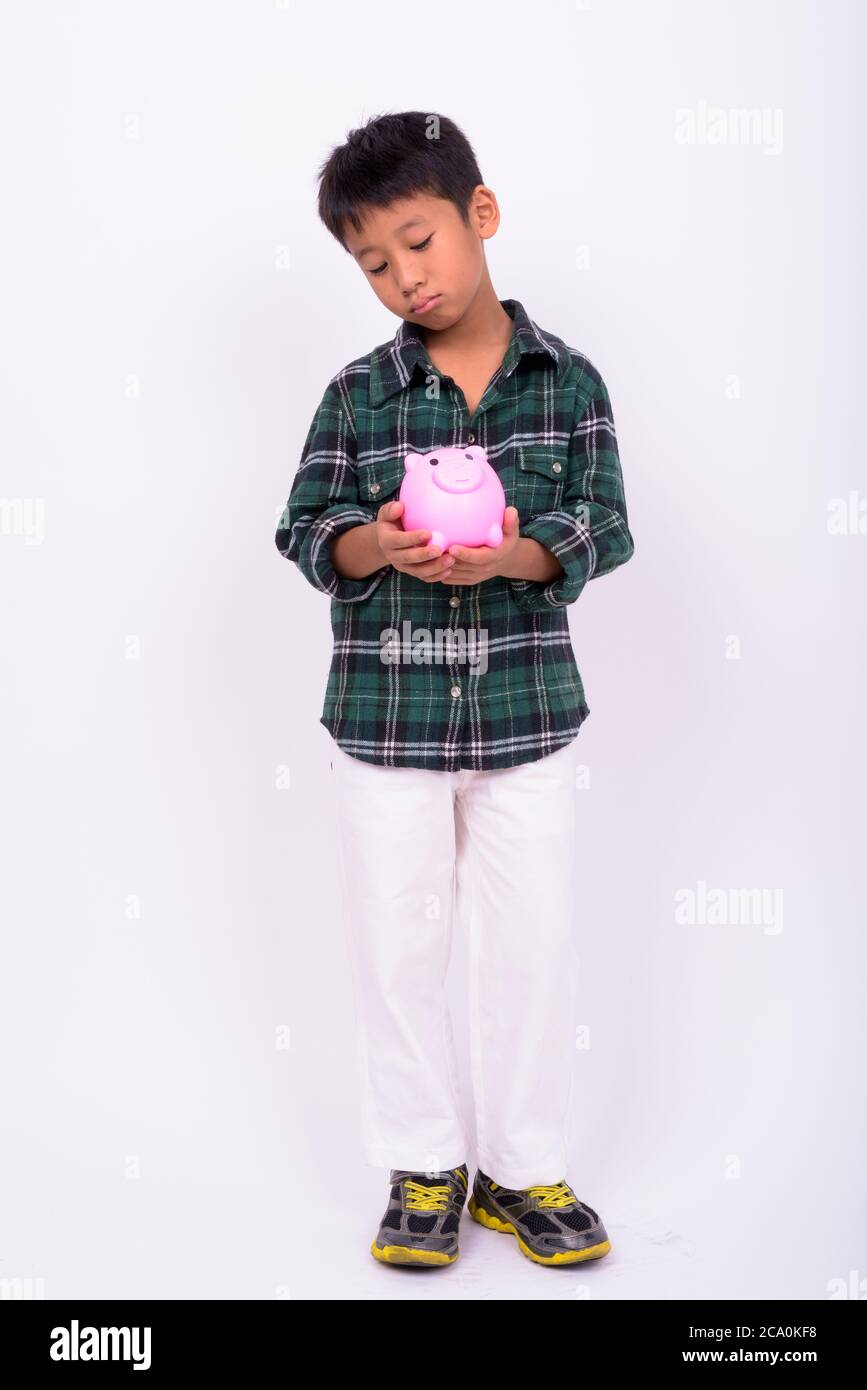 Portrait of cute Asian boy with piggy bank Stock Photo