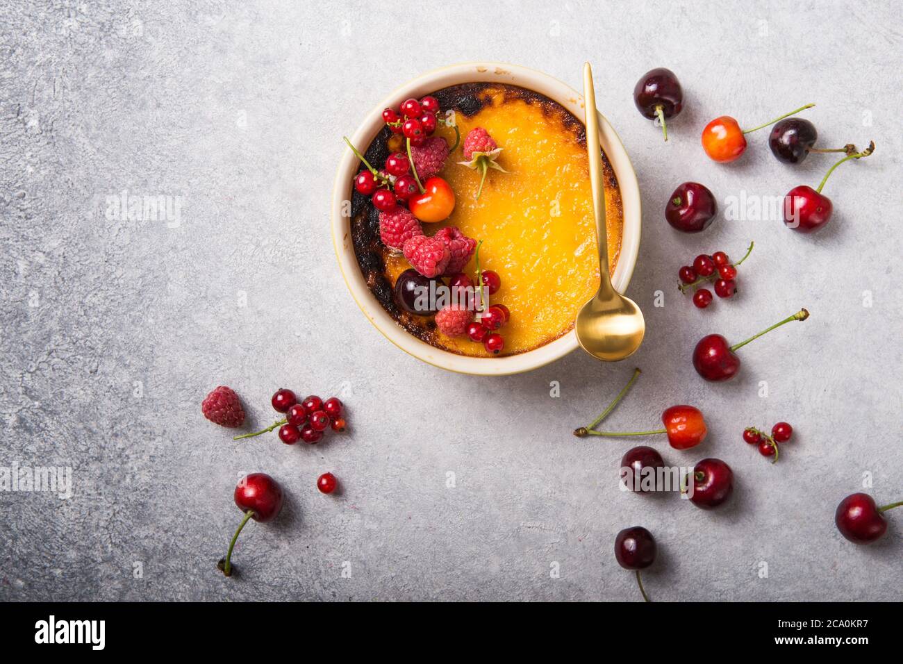 Cremon Raspberry Brulee Creme brulee with raspberry on light baking sheet. Space for your ...