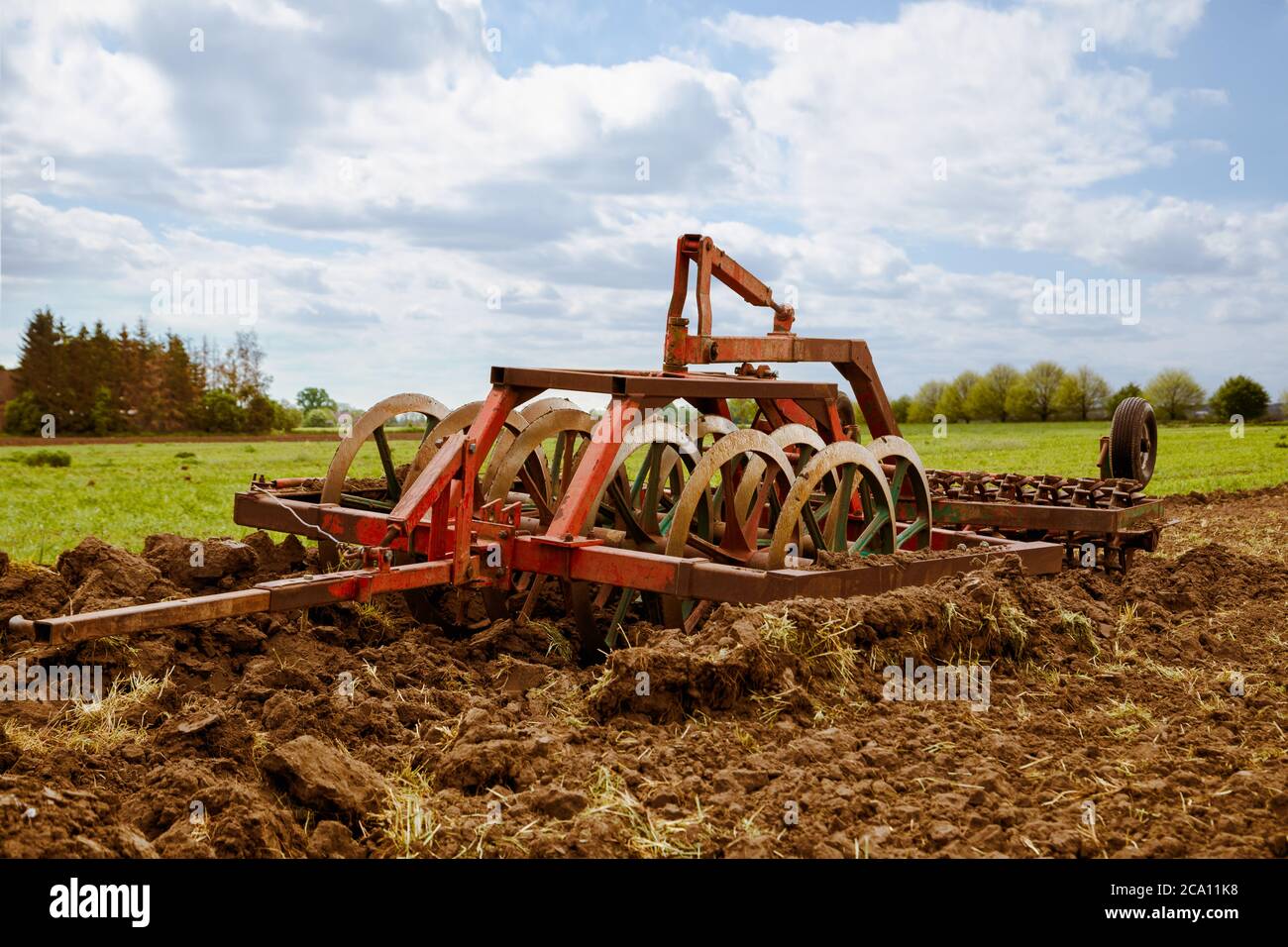 Surface cultivator on ground ready for work at agricultural farmer field Stock Photo