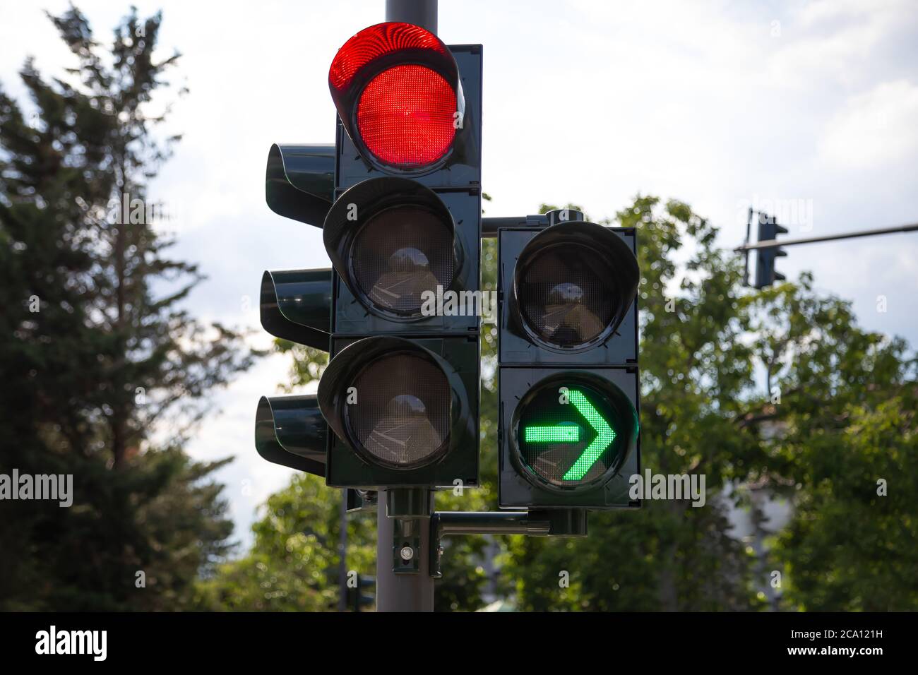 red traffic light light up green arrow that allow to turn right after stopping for the red light but do not have to wait for the traffic light to turn Stock Photo