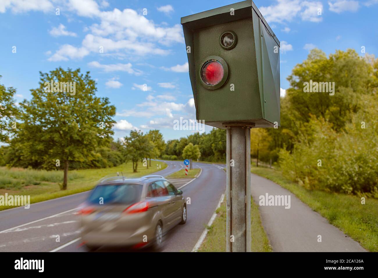 Speed control radar next to street with a car drive by Stock Photo