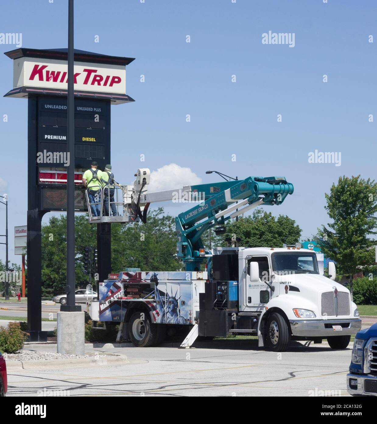 Two men installing sign, working from Kenworth truck with Altec boom lift bucket. Stock Photo