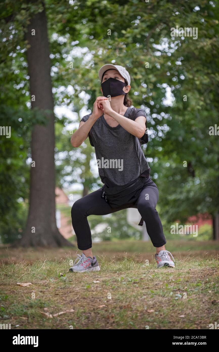A nimble young Asian American stretches near the lake in Kissena Park, Flushing, Queens, New York City. Stock Photo