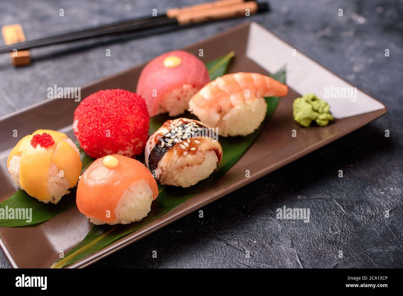 Sushi rolls made of rice, smoked eel, cream cheese and flying fish roeSet hot rolls with avacado, salmon, cream cheese, seaweed, soy sauce, ginger on Stock Photo
