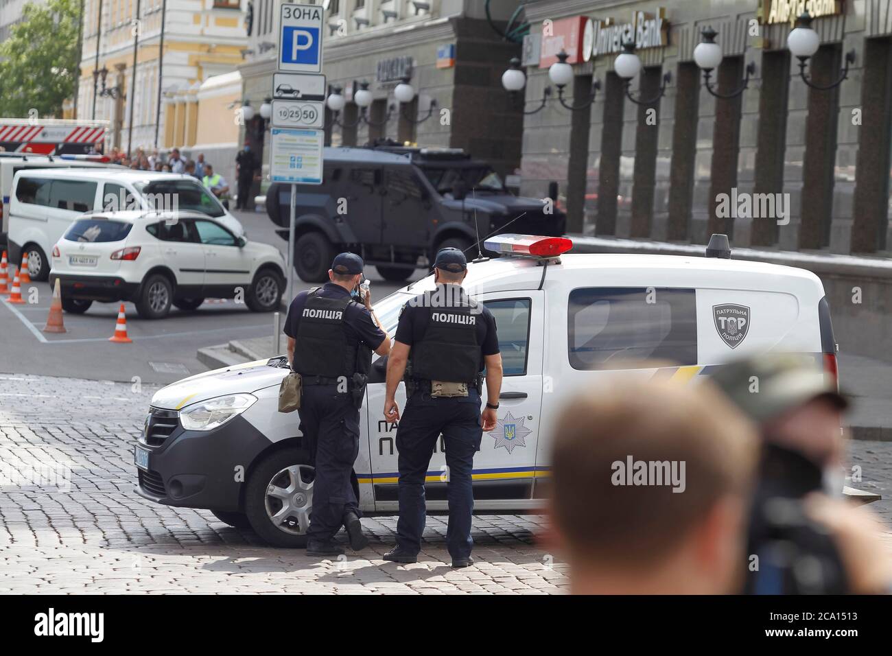 Police officers stand near the building where an unidentified man threatens to blow up a bomb at the Universal bank office.Members of the Security Service of Ukraine (SBU) specops unit detained in a raid a perpetrator, identified as Uzbekistan's Sukhrob Karimov, who threatened to blow up a bank office in the capital city of Kyiv and claimed he was carrying a bomb in his backpack, reportedly by media. Stock Photo