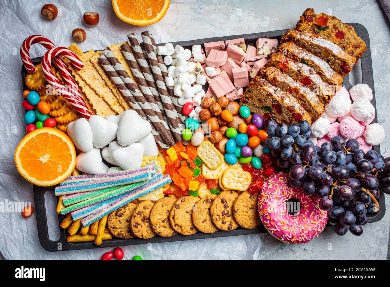 Christmas sweets platter. Christmas fruit cake, candy, chocolate, candy cane, cookies, fruit on