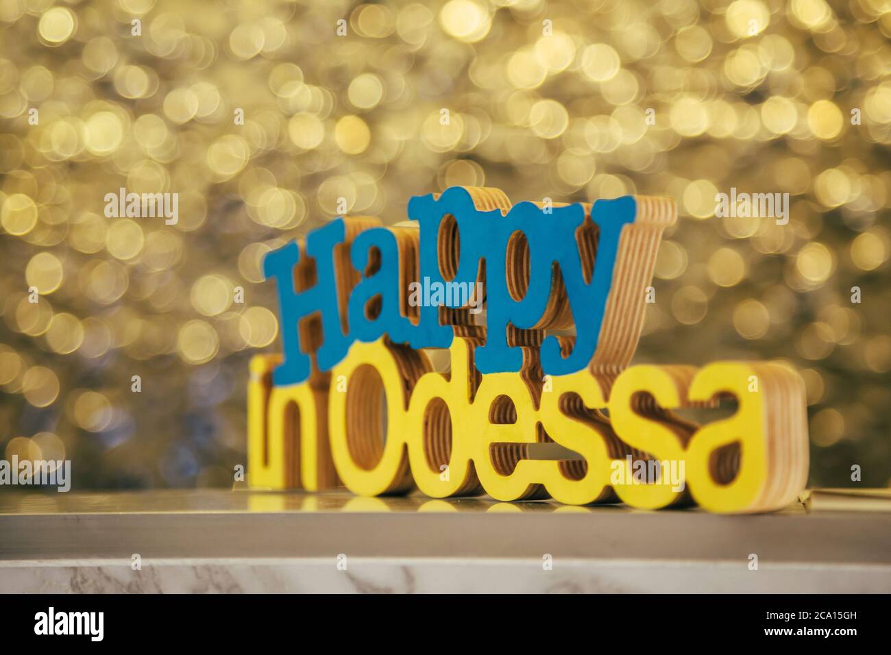 Wood letters Happy in Odessa in blue and yellow colors of the Ukrainian