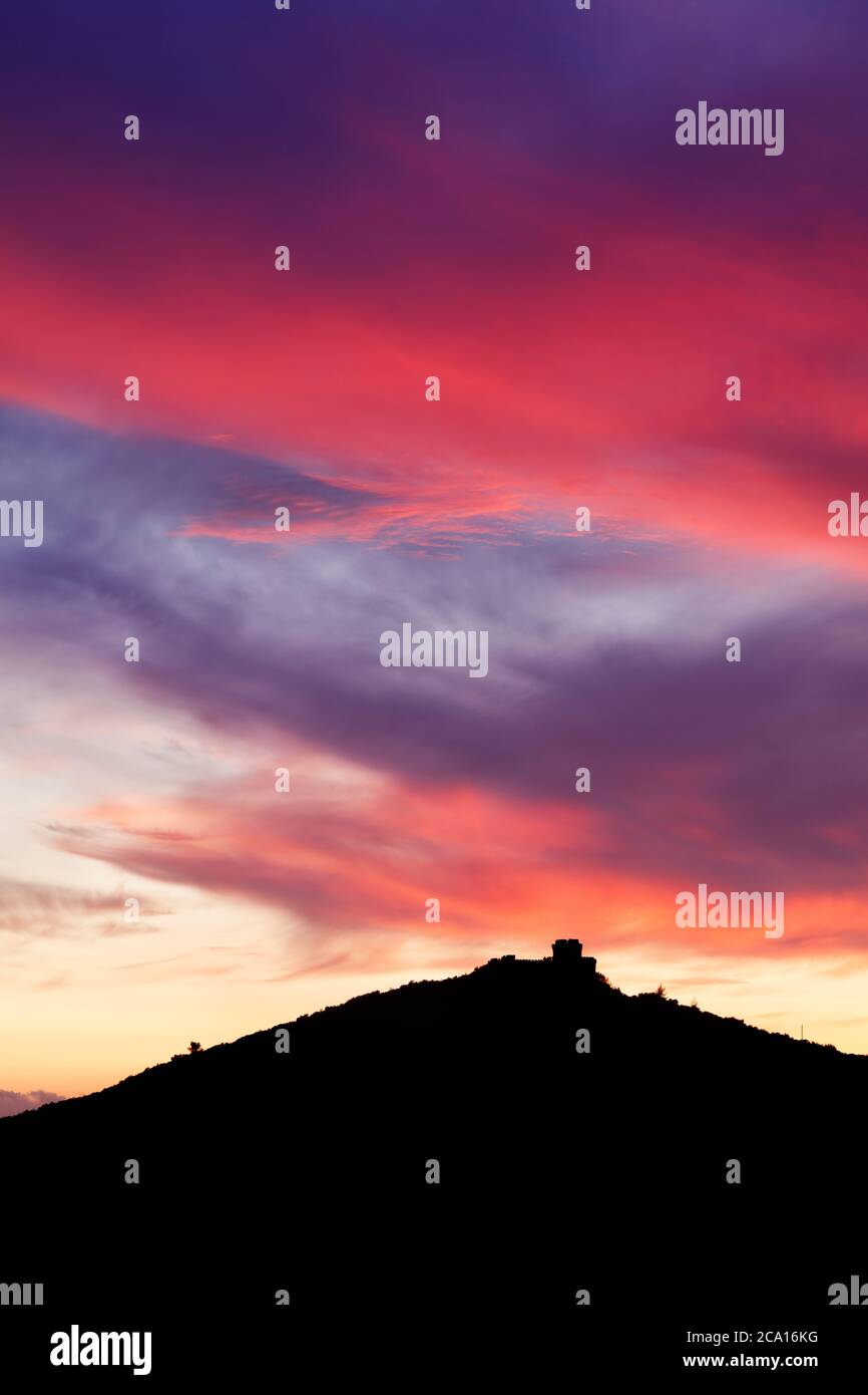 Trikotsova Castle in the Mani peninsula of Greece silhouetted against a dramatic dusk sky Stock Photo