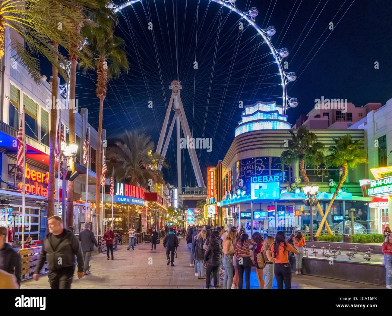 The Linq Promenade at night. Shops, bars and restaurants on The Linq Promenade looking towards the High Roller ferris wheel,  Las Vegas, Nevada, USA Stock Photo