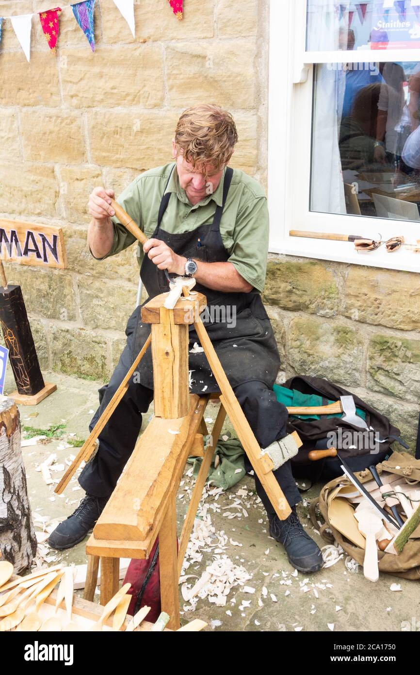 Carpenter using traditional tools and leg operated vice at Staithes art ...
