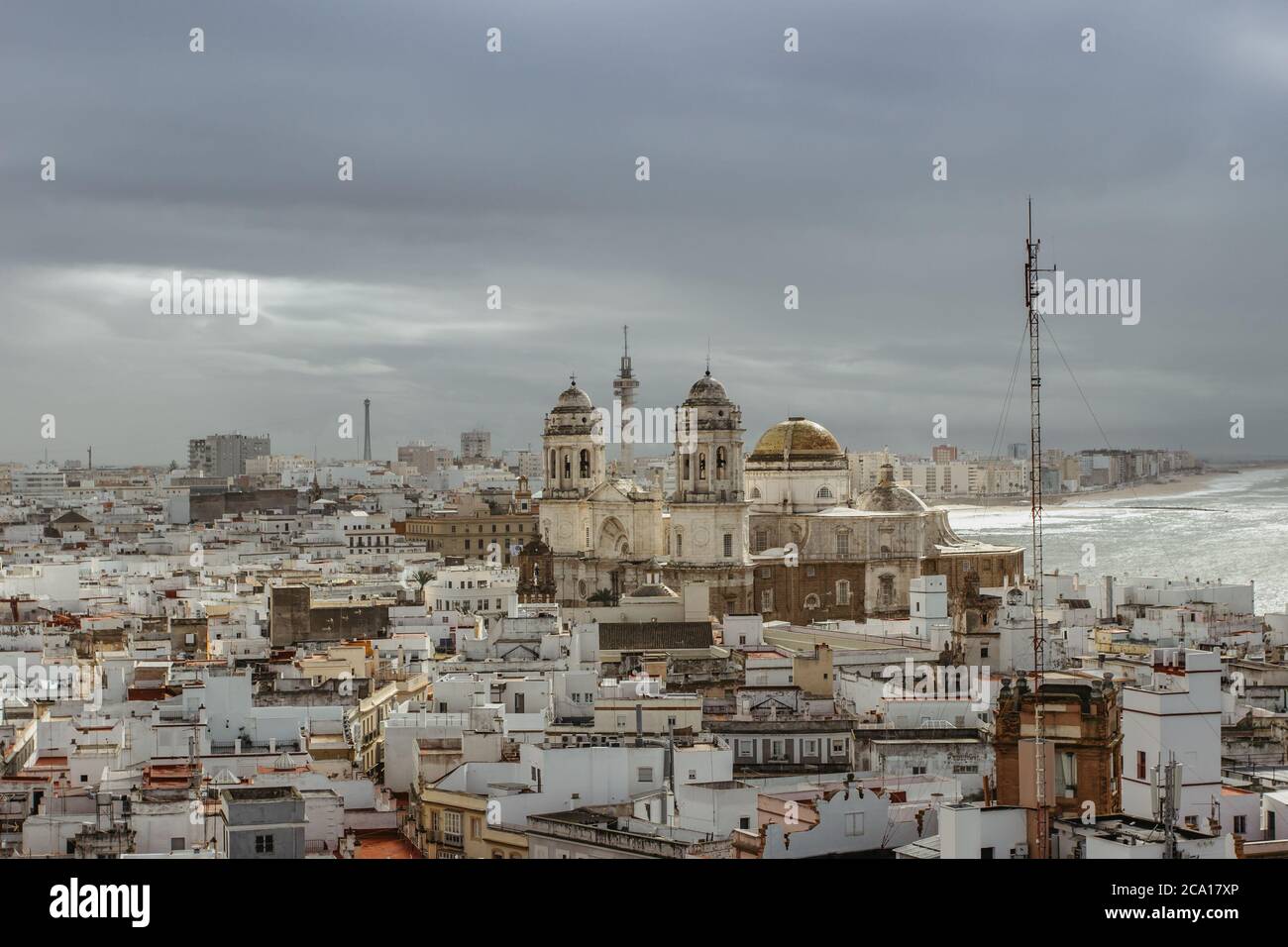 Aerial dramatic panoramic view of the old city, rooftops and Cathedral de Santa Cruz in cloudy day from tower Tavira in Cadiz, Andalusia, Spain.Europe Stock Photo