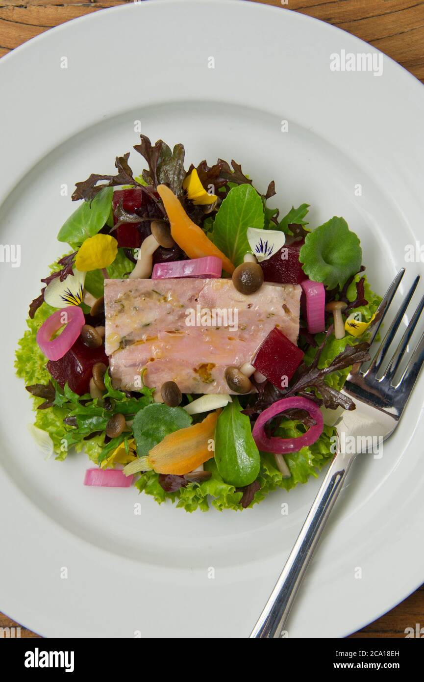 Pork terrine with mixed leaf and edible flower salad Stock Photo