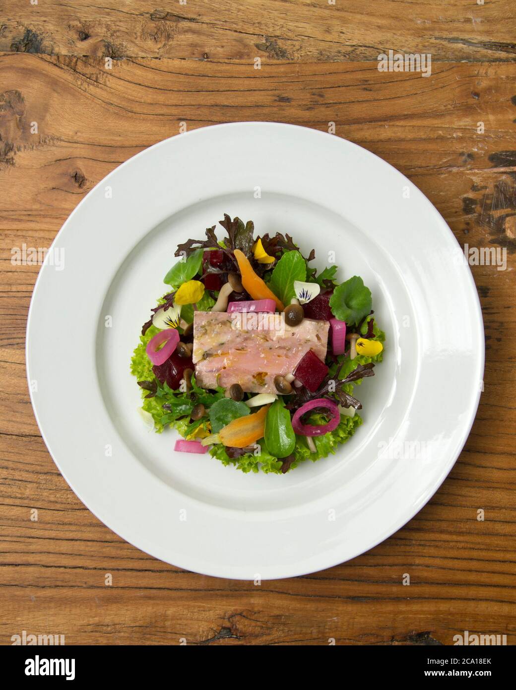 Pork terrine with mixed leaf and edible flower salad Stock Photo