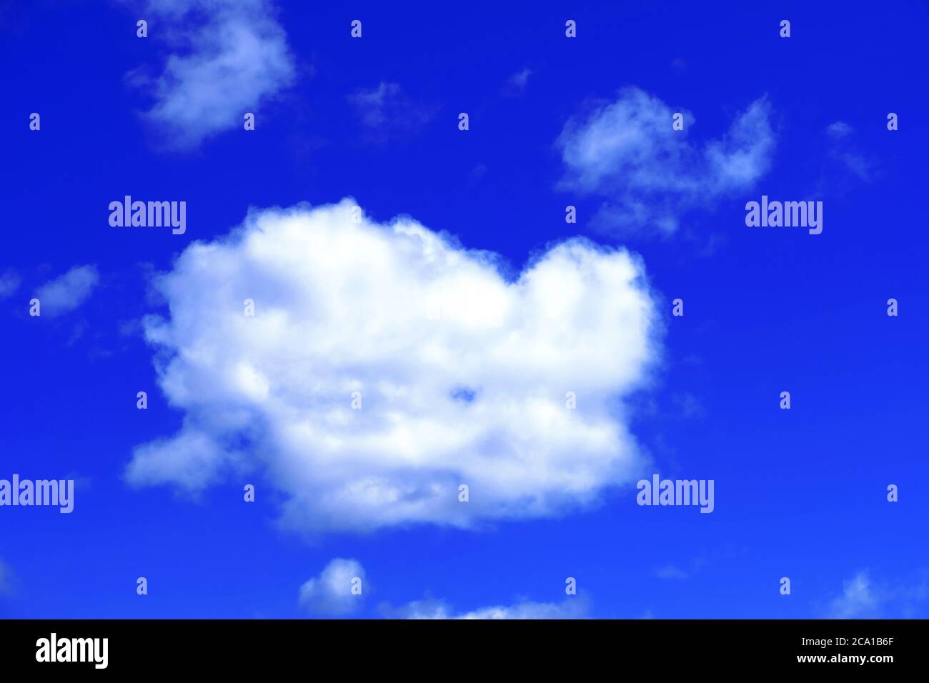 Single white fluffy cumulus cloud against deep blue sky Stock Photo
