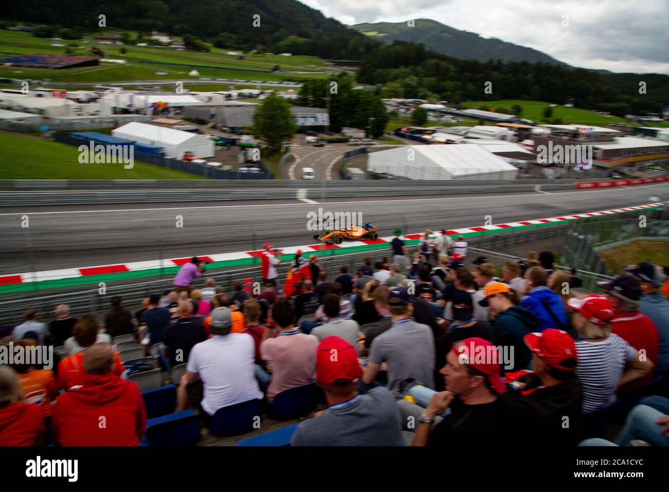 A spectators view of Fernando Alonso's Mclaren Formula One car nerar the 1st Corner of the Red Bull ring, Austria 2018 Stock Photo