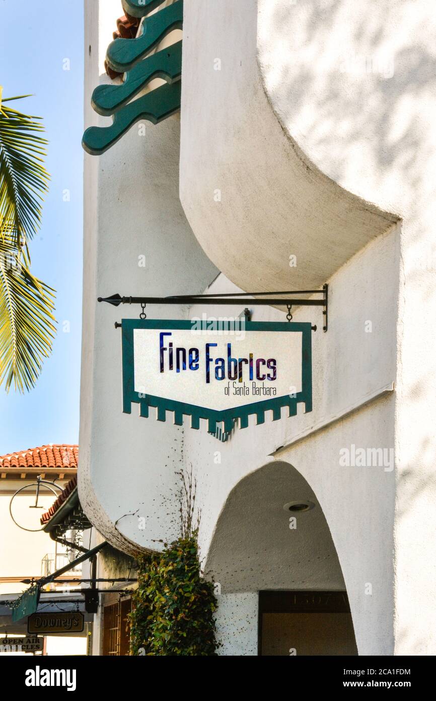 Modern building with Overhead metal sign for 'Fine Fabrics of Santa Barbara' shop on State Street in popular downtown Santa Barbara, CA Stock Photo