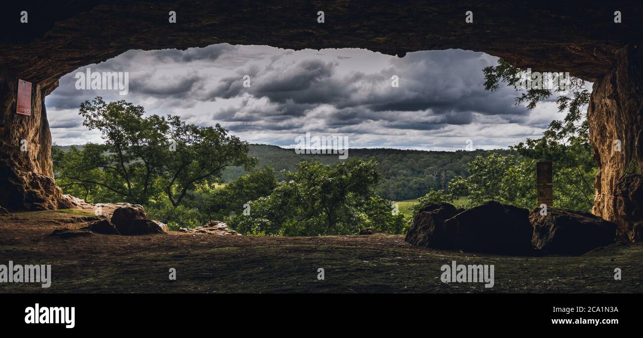 A photo from taken from inside of Miller Cave towards to the outside. Invokes a dark to light theme. Miller Cave is located in Fort Leonard Wood, MO. Stock Photo