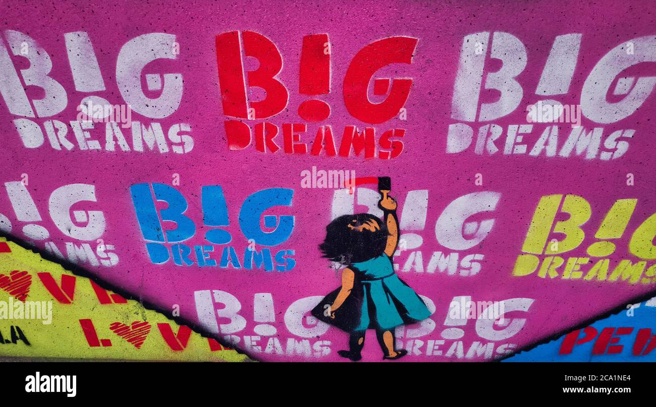 Mural art (graffiti) showing a little girl (from the back) writing I LOVE BIG DREAMS in different colors and sizes Stock Photo